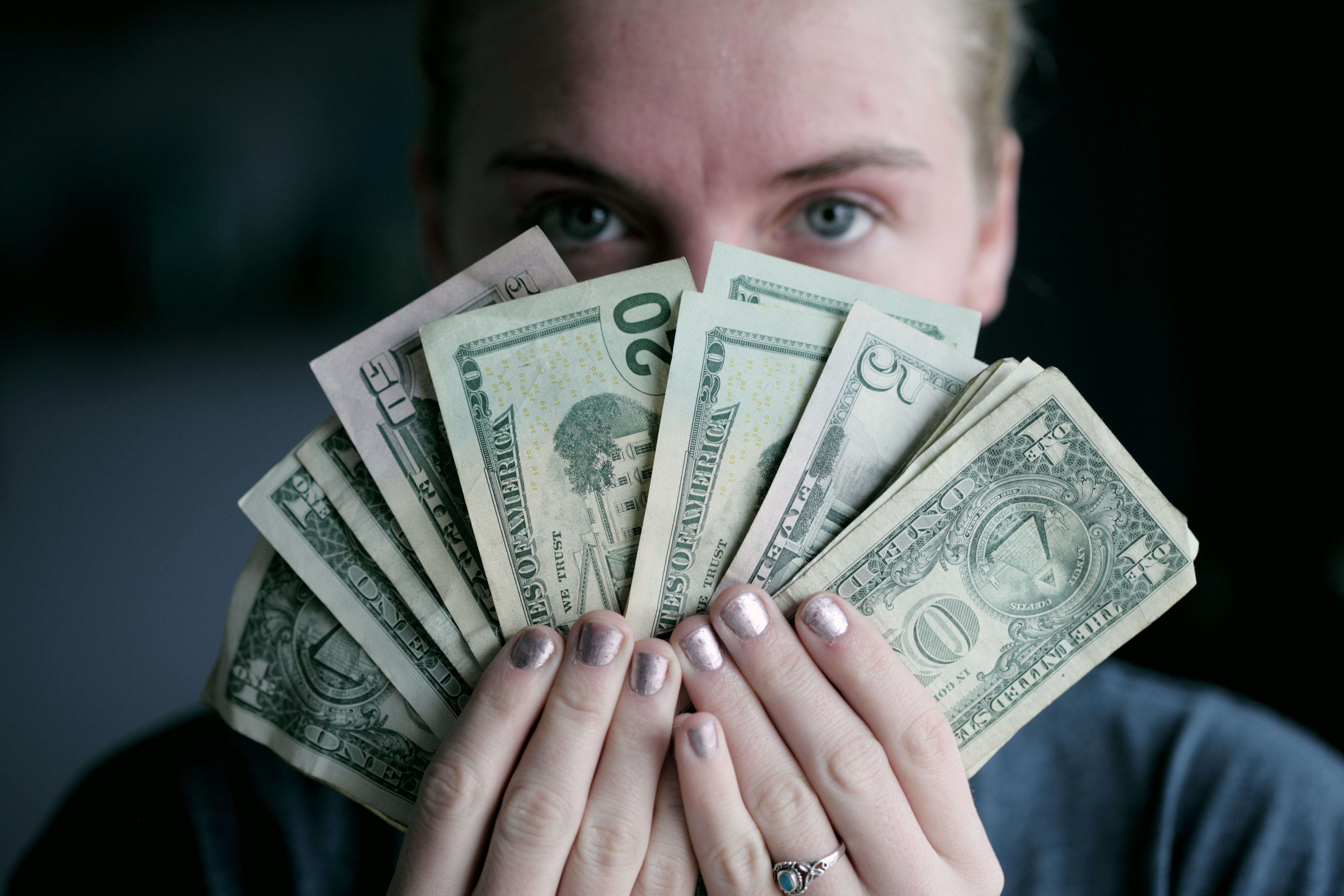 woman holding money after tax preparation season